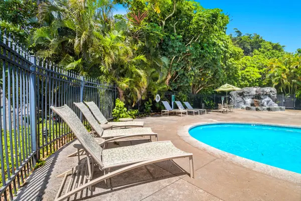 Gated Pool with Loungers and Tropical Garden Backdrop