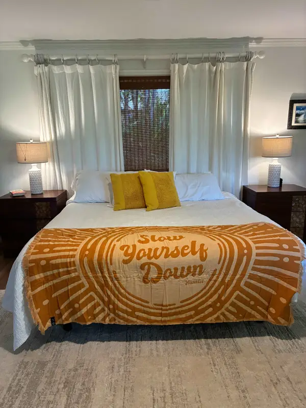 Cozy primary bedroom setup with bedside tables, lamps, and soft drapes
