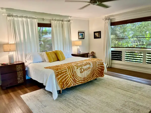 Bright master bedroom with king bed, large windows, and scenic views