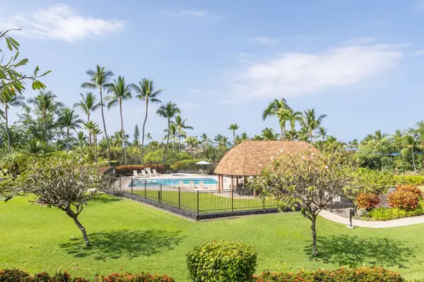 Landscaped grounds leading toward the gated pool and cabana