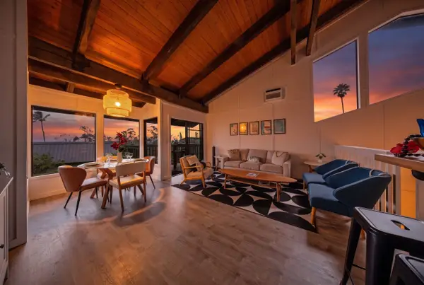 Living and dining area with wooden beam ceilings and lanai view