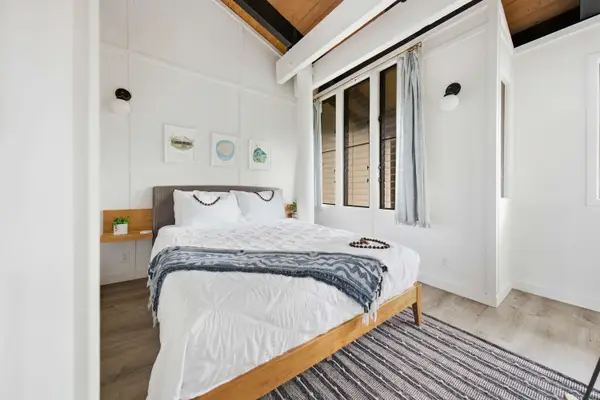 Third bedroom with queen bed and bright windows