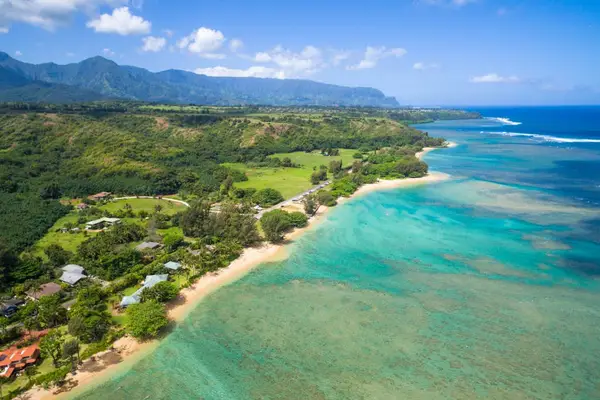 Aerial coastline view reveals turquoise water, sandy beaches, and valleys