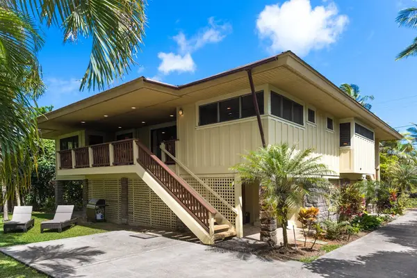 Elevated home exterior features tropical landscaping, stairs, and welcoming architecture