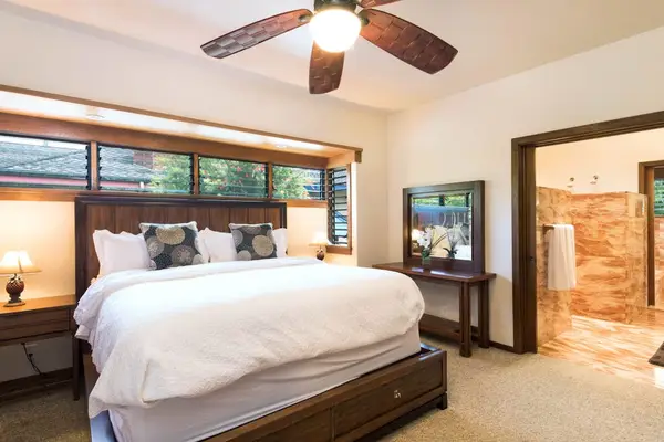 Cozy bedroom presents a comfortable bed, ceiling fan, and windows