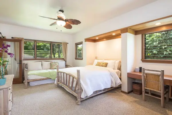 Bright bedroom offers twin beds, natural light, and garden views