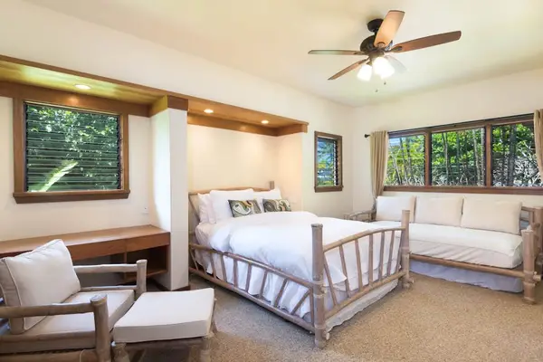 Peaceful bedroom presents a bed, bedside table, and framed artwork