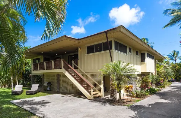 Home exterior showcases elevated architecture, tropical landscaping, and welcoming stairs