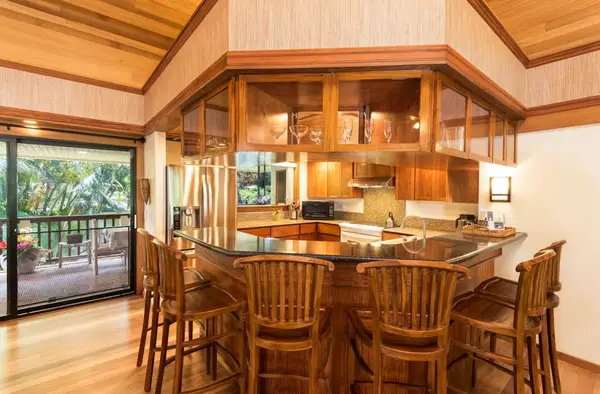 Kitchen features a breakfast bar, wooden cabinetry, and organized appliances
