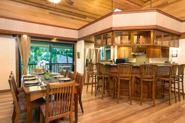 Warm kitchen and dining area feature wood cabinetry and island seating