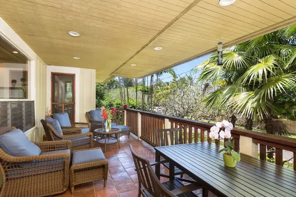 Covered patio offers comfortable furnishings, garden views, and breezy relaxation