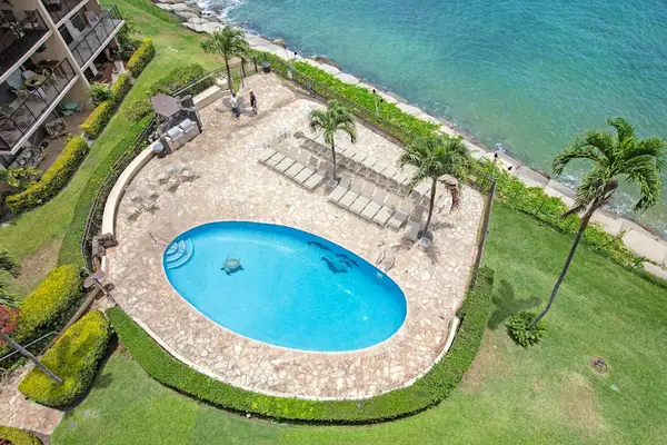 Aerial view of Hololani Resort community pool.  Amazing pool, swaying palm trees and steps to the ocean.