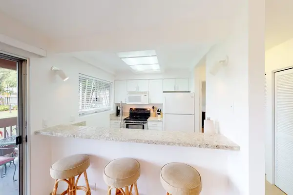 Three barstools at kitchen counter for extra seating.