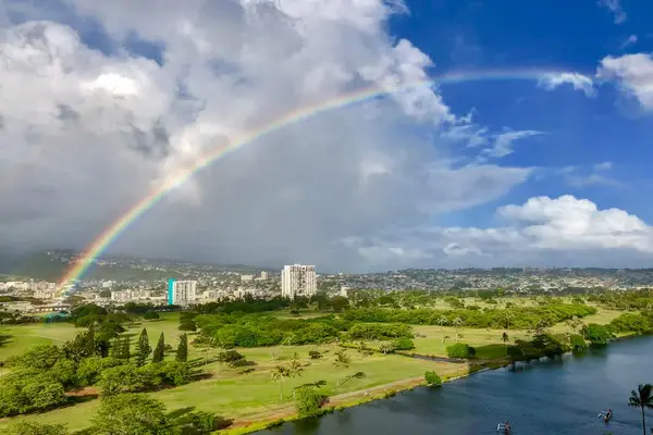 Catch a stunning Hawaiian rainbow stretching across the skyline.
