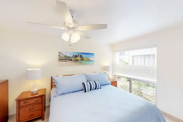 Guest room with queen bed, flat screen tv and lanai access.