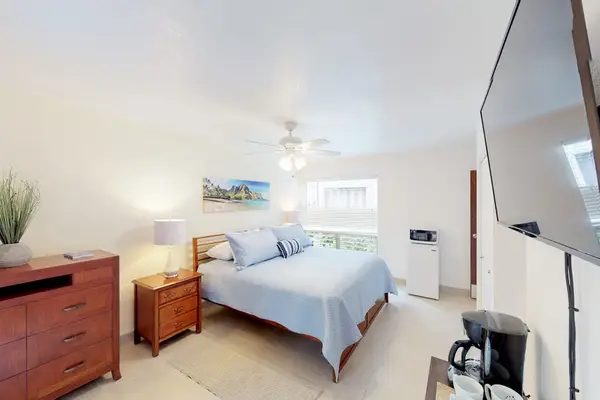 Guest room with queen bed, flat screen tv and lanai access.