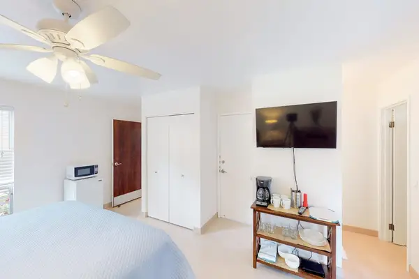 Guest room with queen bed, flat screen tv and lanai access.