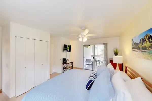 Guest room with queen bed, flat screen tv and lanai access.