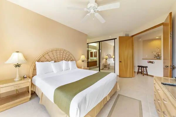 Bedroom offers bedding, bedside tables, ceiling fan, artwork, and windows