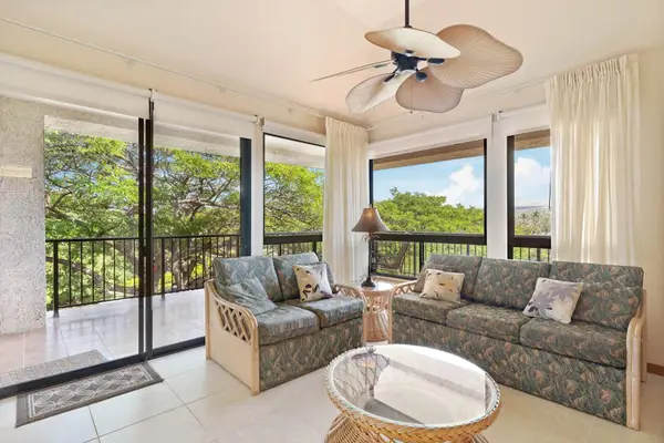 Floor-to-ceiling glass frames stunning views from this inviting open living room retreat