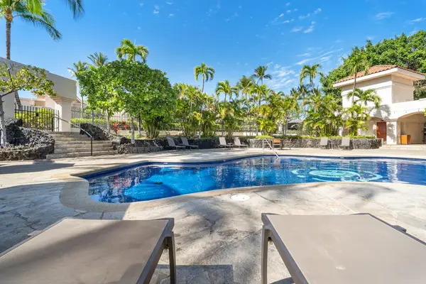 Resort pool sparkles beside palms, loungers, railings, and sunny skies