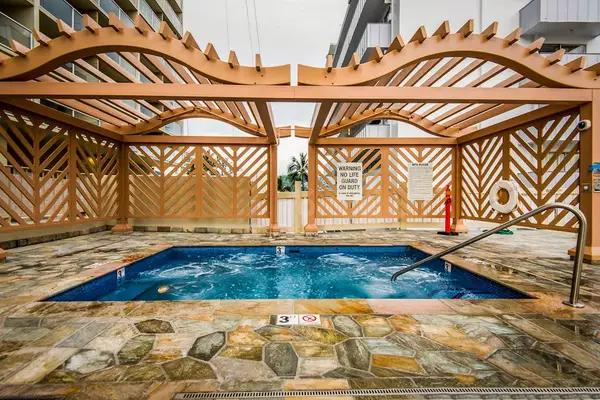 Enjoy a soothing soak under elegant pergolas while embracing the warmth of a tropical escape.