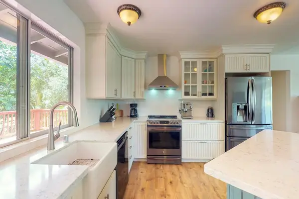 Newly remodeled kitchen with stainless steel appliances and a large picture window over the farmhouse sink for plenty of natural light.