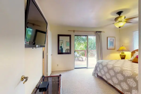 Master bedroom with king bed, flat screen tv and light from the lanai.