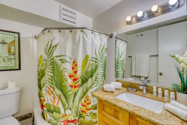 Full bathroom with a shower-tub combination, tropical décor, and hotel-style amenities for your comfort.