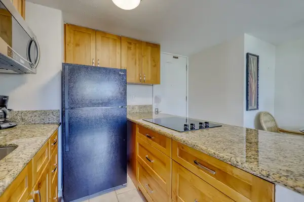 Modern kitchen with ample counter space and essential cookware for convenient extended stays in Waikiki.