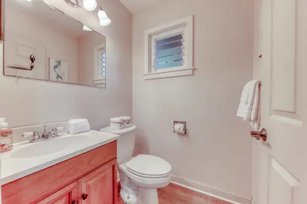 Full Bathroom Featuring Warm Wood Vanity & Wall Mirror