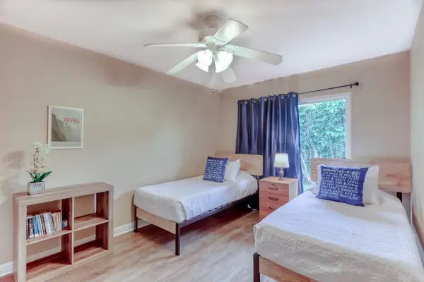 Bright Second Bedroom with Two Twin Beds & Ceiling Fan