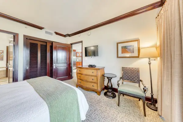 Second Bedroom Featuring Armchair Seating, Dresser & Wall TV