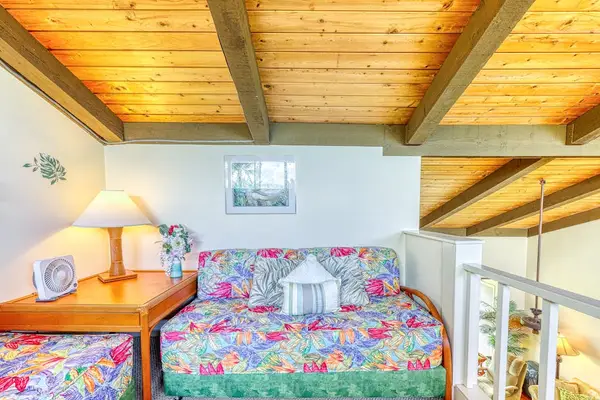 Cozy up under beautiful, exposed wooden beams! This charming loft space offers comfortable twin beds and warm lighting for a relaxing night's sleep. 🛏️🪵✨