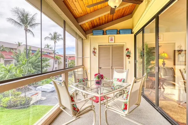 Charming balcony dining setup with a glass-top table, ceiling fan, and peaceful palm tree views! 🌴🍃🍴