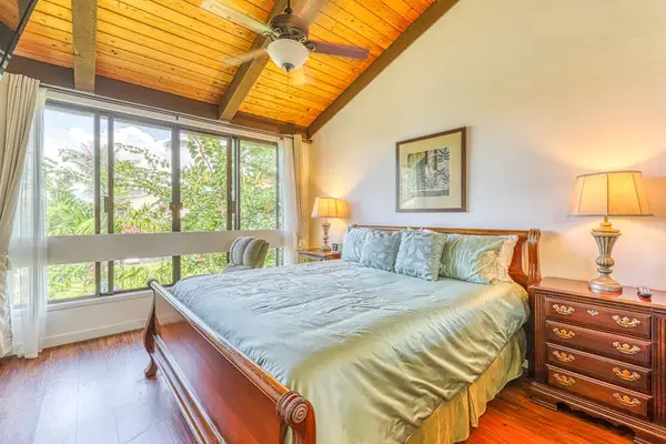 Sleep peacefully under gorgeous wood-beamed ceilings! This spacious primary bedroom features a comfortable king-size bed and calming garden views. 🛏️🌿✨