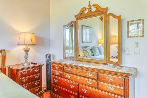 Unpack and settle in! Enjoy plenty of storage space with a large wooden dresser and a gorgeous tri-fold mirror perfect for getting ready. 👗🪞✨