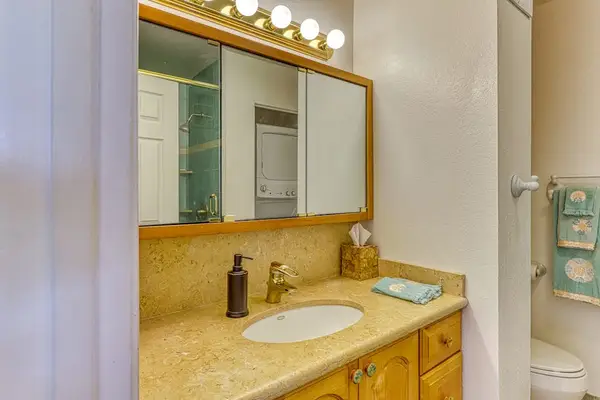 A cozy, well-lit bathroom vanity offering plenty of under-sink storage, convenient hand soap, and a clean setup designed for your comfort! 🚿🪞🏡