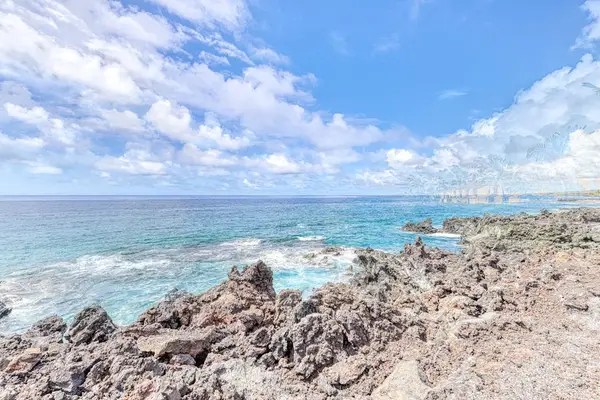 Breathe in the salty air and listen to the soothing sound of turquoise waves crashing against the dramatic, rocky shoreline. 🌊✨