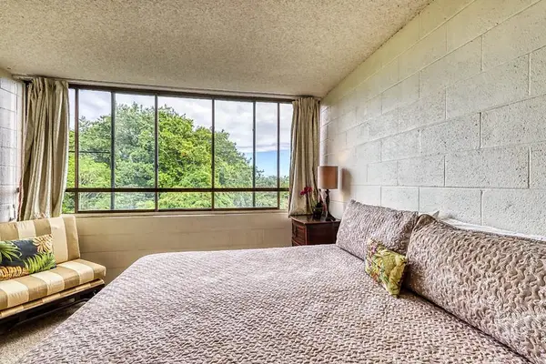 Primary bedroom overlooking lush greenery