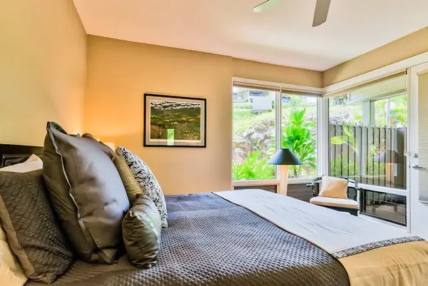 Master bedroom with king bed, flat screen tv and large windows for tropical views and private lanai access.