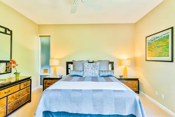 Master bedroom with king bed and large windows for tropical views and private lanai access.