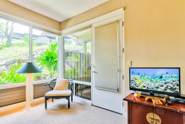 Master bedroom with king bed, flat screen tv and large windows for tropical views and private lanai access.