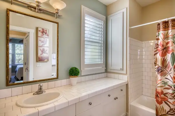 Bright Guest Bathroom with Large Mirror & Floral Shower Curtain