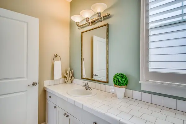 Clean White Vanity with Ample Countertop & Plantation Shutters