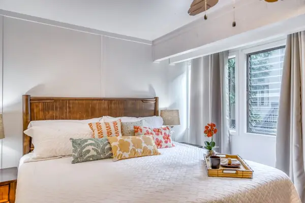 Sunlit Bedroom Retreat with Plush Bedding & Tropical Charm