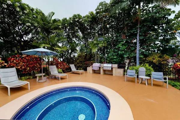 Unwind in the inviting hot tub surrounded by tropical landscaping