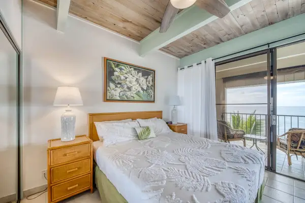 Primary bedroom with direct access to the private lanai and ocean views.