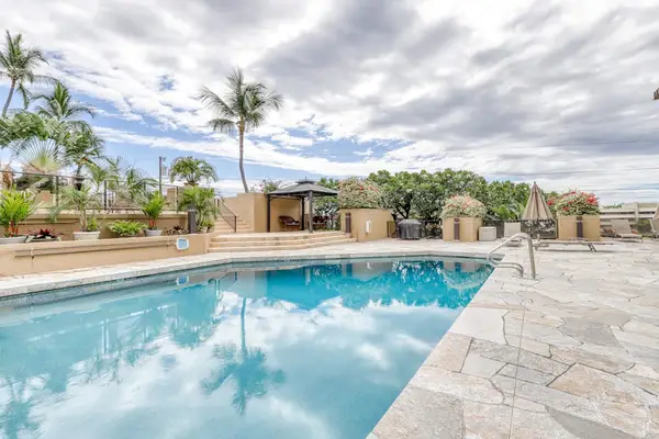 Spacious community swimming pool featuring a large paved stone sun deck, clear blue water, and iconic tropical palm tree landscaping! 🎛️📐