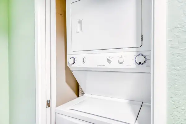 In-unit stacked laundry center featuring a white washer and dryer setup for effortless clothing care during your trip! 🧺⚡